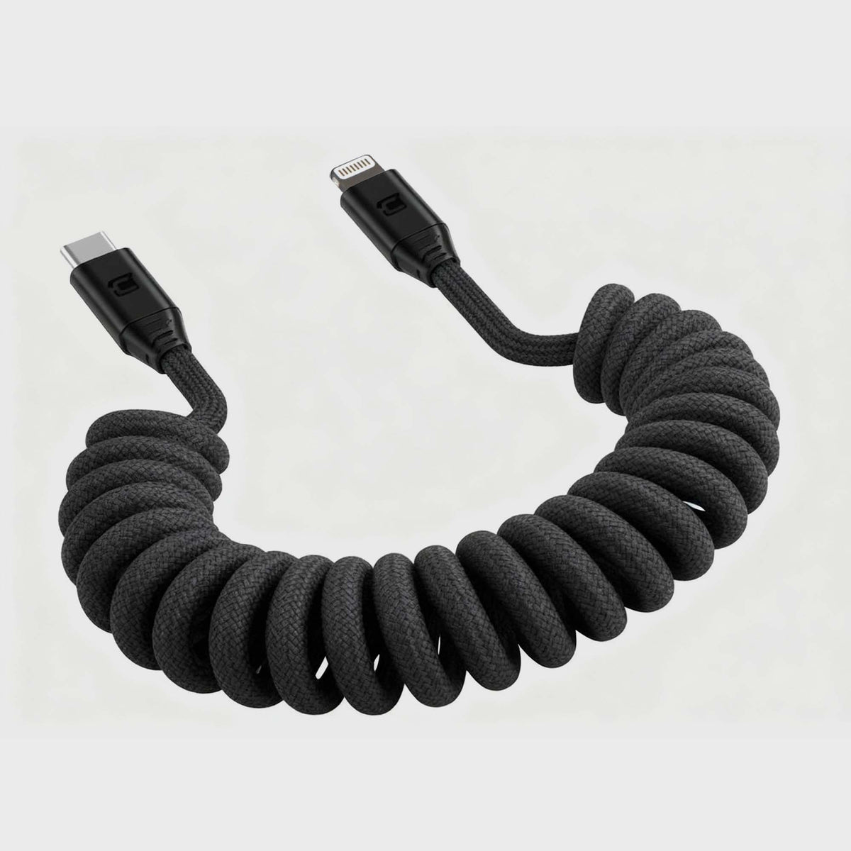 Close-up of black coiled USB-C to Lightning cable with reinforced connectors, on a white background, highlighting durable braided material