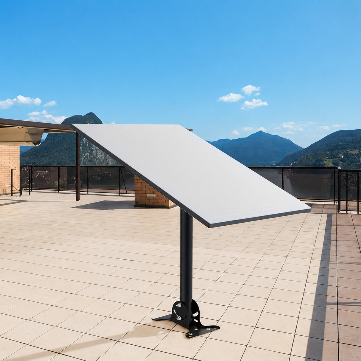 Wide-angle view of the satellite dish mounted on a roof with mountain landscape in the background, under a clear blue sky