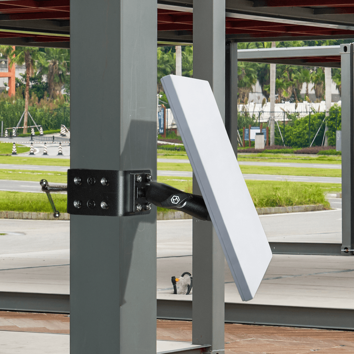 Starlink Mini mounted on a stable desk mount with black plastic base, adjustable arm, and secure clamping mechanism in an outdoor setting